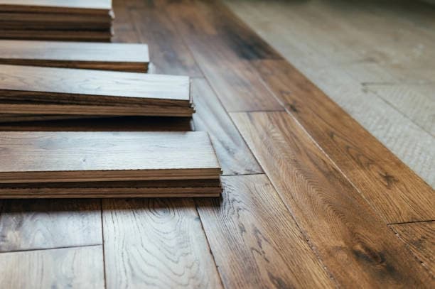 Loose flooring planks stacked on a partially installed wood-look floor during an installation