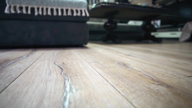 Floor-level view of light wood-look plank flooring in a furnished living room