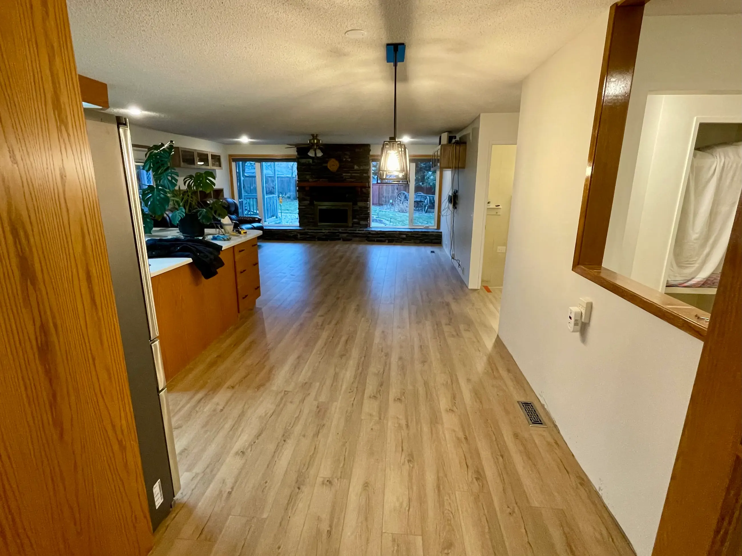 Warm wood-look vinyl plank flooring installed from kitchen into living room